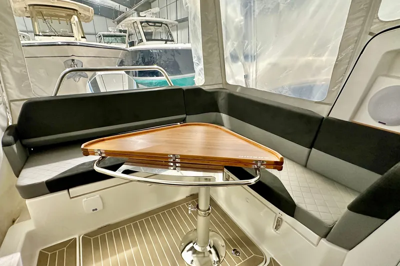 Delphin Yacht Photos Pics Interior of 2023 Nimbus Weekender 9 boat with sleek seating and wooden table.
