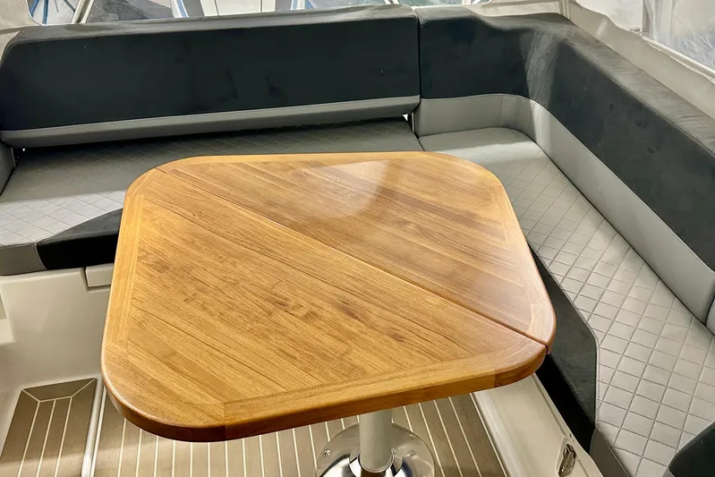 Delphin Yacht Photos Pics 2023 Nimbus Weekender 9 interior with wooden table and cushioned seating.