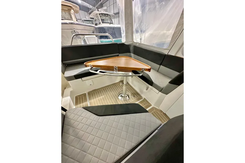 Delphin Yacht Photos Pics Interior of 2023 Nimbus Weekender 9 boat with seating and wooden table.