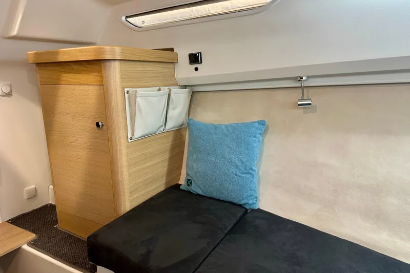 Delphin Yacht Photos Pics Interior of 2023 Nimbus Weekender 9, featuring cozy seating and wooden cabinetry.