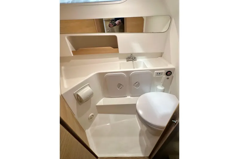 Delphin Yacht Photos Pics Compact bathroom in 2023 Nimbus Weekender 9 boat, featuring sink, toilet, and storage.