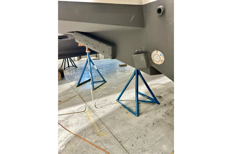 Delphin Yacht Photos Pics 2023 Nimbus Weekender 9 boat hull on blue stands in a workshop.