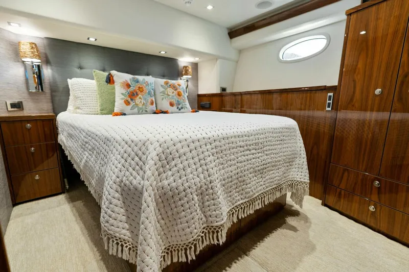 Mana Yacht Photos Pics Luxurious bedroom in 2021 Viking 82 Cockpit Motor Yacht with elegant wood finishes.