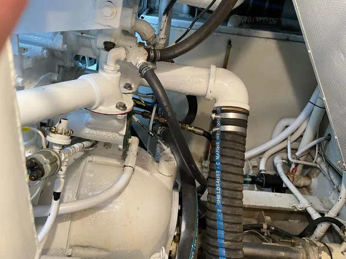  Yacht Photos Pics Engine room of a 1965 Burger 78' Cockpit Flybridge Motor Yacht with various pipes and hoses.