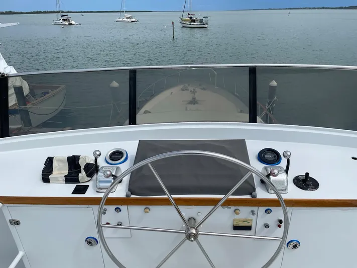  Yacht Photos Pics 1965 Burger 78' Cockpit Flybridge Motor Yacht helm overlooking calm waters and anchored boats.