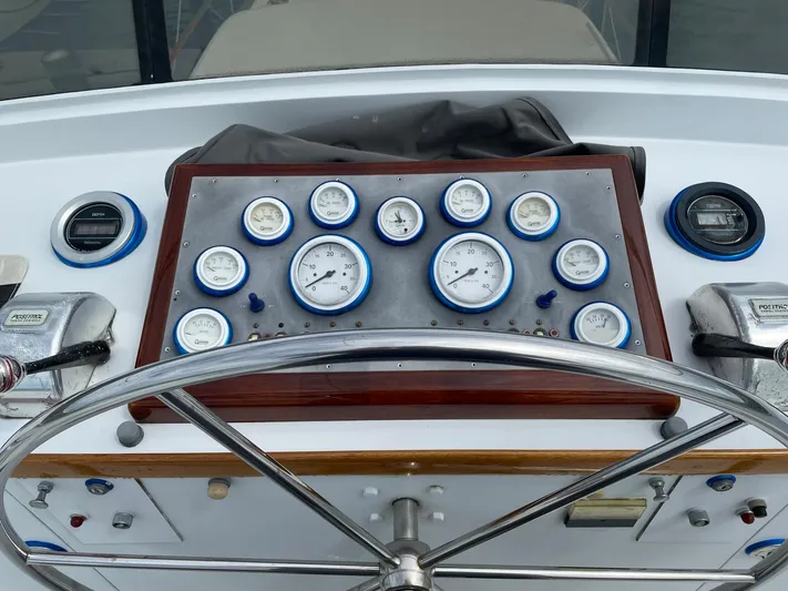  Yacht Photos Pics Cockpit dashboard of a 1965 Burger 78' Cockpit Flybridge Motor Yacht with gauges and steering wheel.