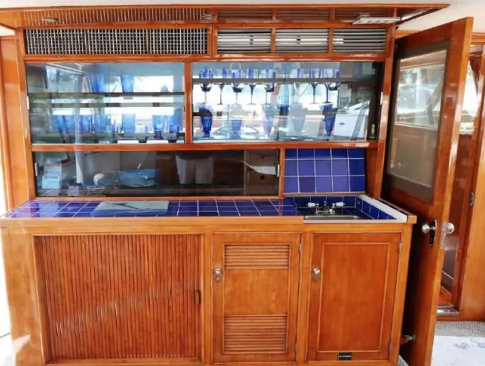  Yacht Photos Pics Interior of 1965 Burger 78' Cockpit Flybridge Motor Yacht with wooden cabinetry and blue-tiled countertop.