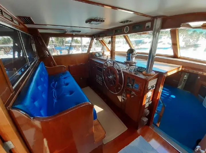  Yacht Photos Pics Interior of a 1965 Burger 78' Cockpit Flybridge Motor Yacht with blue seating and wooden finishes.