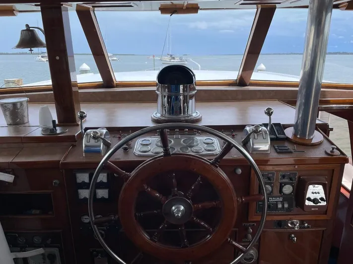  Yacht Photos Pics Cockpit of 1965 Burger 78' Flybridge Motor Yacht with wooden steering wheel and nautical controls.