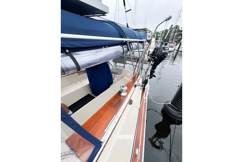 Delicia Yacht Photos Pics 1995 Island Packet 40 sailboat docked, featuring a blue cover and wooden deck details.