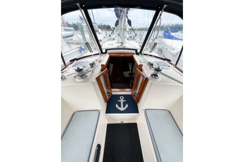 Delicia Yacht Photos Pics 1995 Island Packet 40 sailboat cockpit with anchor-themed mat and seating.