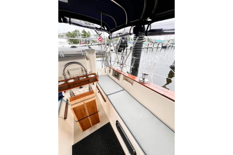 Delicia Yacht Photos Pics 1995 Island Packet 40 sailboat cockpit with seating, helm, and marina view.
