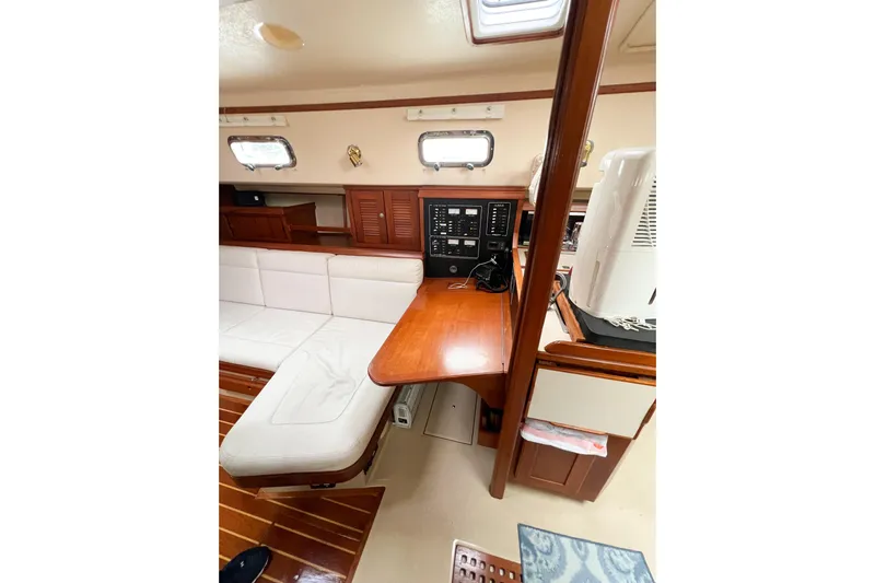 Delicia Yacht Photos Pics Interior of 1995 Island Packet 40 yacht with white seating and wooden accents.