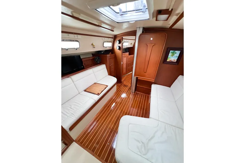 Delicia Yacht Photos Pics Interior of 1995 Island Packet 40 yacht with elegant wood finish and white seating.