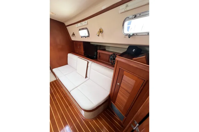 Delicia Yacht Photos Pics Interior of 1995 Island Packet 40 yacht with white seating and wooden accents.
