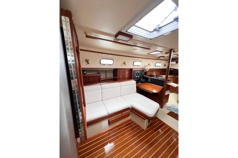Delicia Yacht Photos Pics Interior of 1995 Island Packet 40 yacht with white seating and wooden accents.
