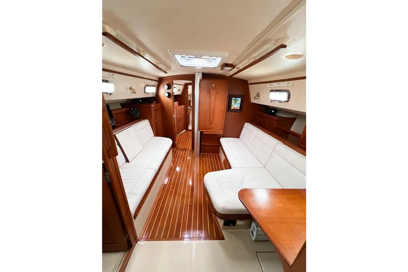 Delicia Yacht Photos Pics Interior of 1995 Island Packet 40 sailboat with elegant wood finish and white seating.