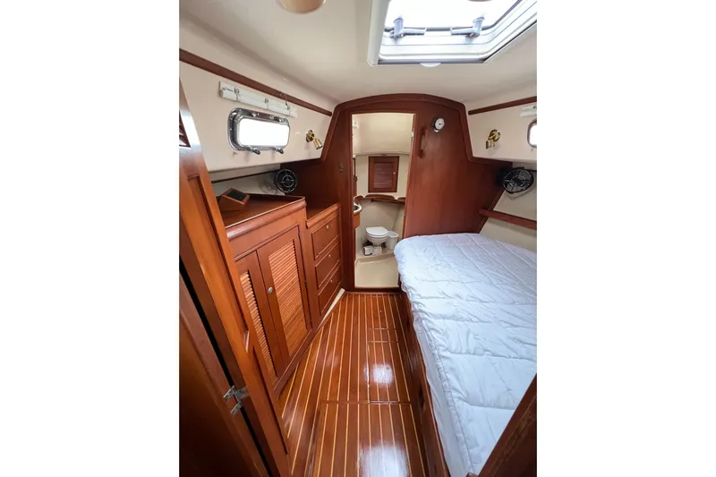 Delicia Yacht Photos Pics Cozy cabin interior of 1995 Island Packet 40 sailboat with wood finish and bed.