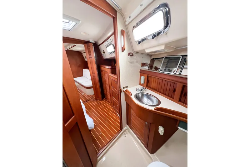 Delicia Yacht Photos Pics Interior of 1995 Island Packet 40 sailboat with wooden cabinetry and compact bathroom.