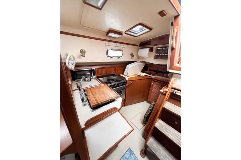 Delicia Yacht Photos Pics Interior of 1995 Island Packet 40 sailboat galley with wood cabinetry and appliances.