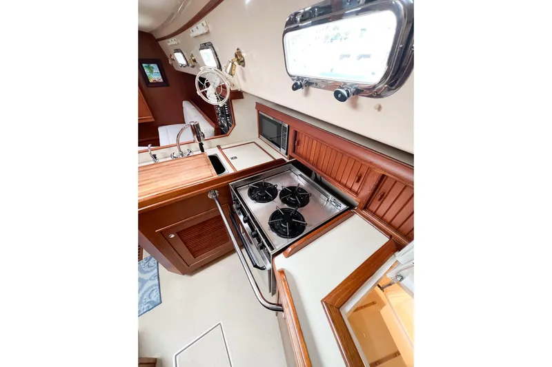 Delicia Yacht Photos Pics Interior of 1995 Island Packet 40 yacht, featuring a compact kitchen with stove and sink.