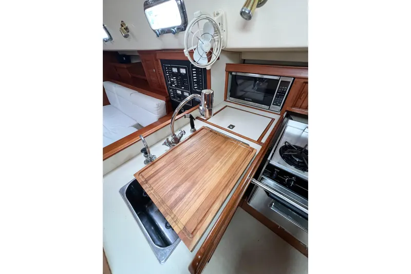 Delicia Yacht Photos Pics Interior of 1995 Island Packet 40 yacht kitchen with sink, stove, and microwave.