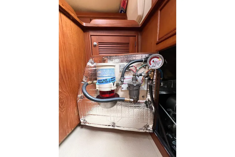 Delicia Yacht Photos Pics Engine compartment of a 1995 Island Packet 40 sailboat, featuring fuel filter and gauge.