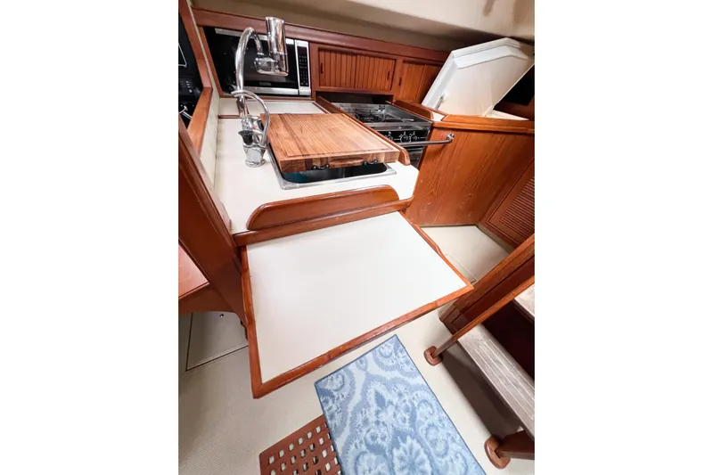 Delicia Yacht Photos Pics 1995 Island Packet 40 yacht kitchen with wooden cabinetry and modern appliances.