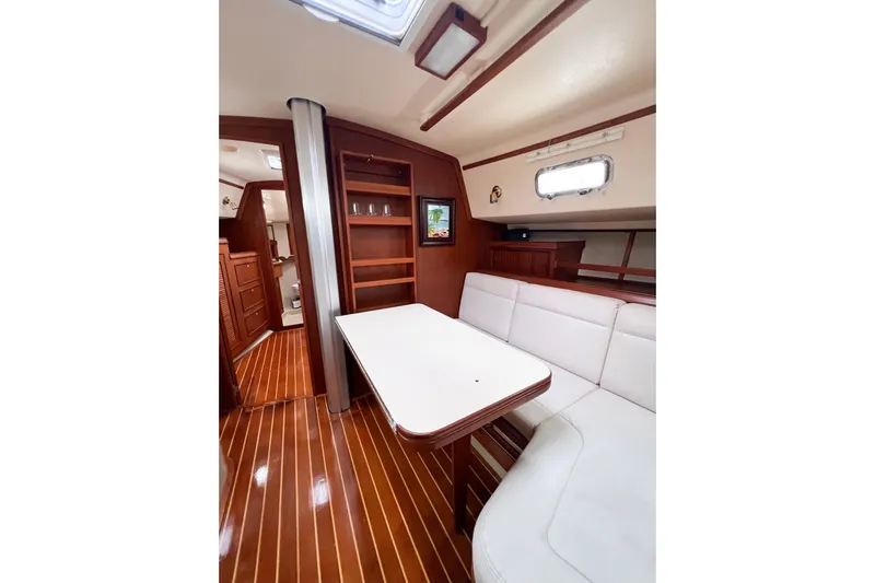 Delicia Yacht Photos Pics Interior of 1995 Island Packet 40 sailboat with wood flooring and white seating.
