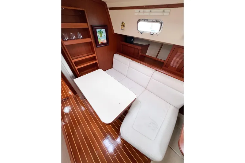 Delicia Yacht Photos Pics Interior of 1995 Island Packet 40 yacht with white seating and wooden accents.