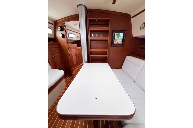 Delicia Yacht Photos Pics Interior of 1995 Island Packet 40 sailboat with wooden cabinetry and white seating.