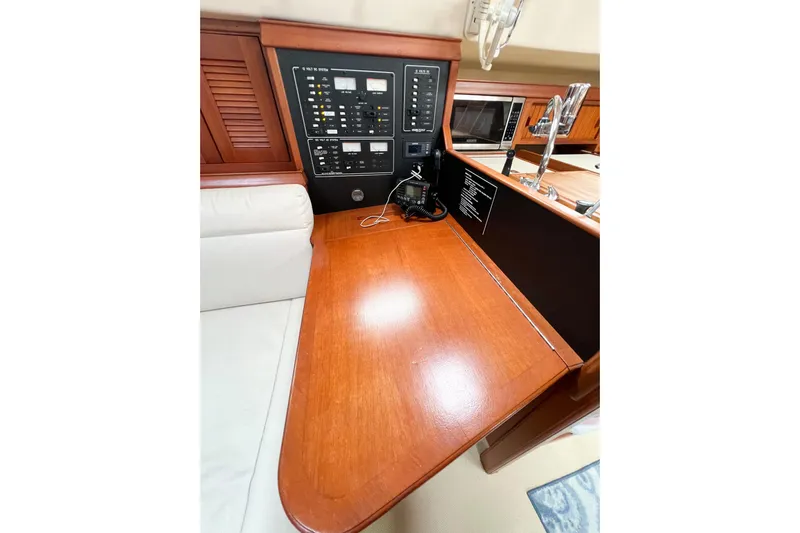 Delicia Yacht Photos Pics Interior of 1995 Island Packet 40 yacht with navigation panel and wooden finish.