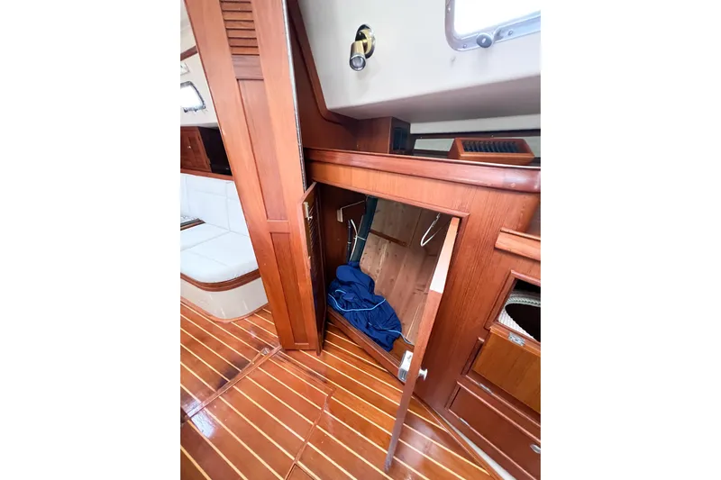 Delicia Yacht Photos Pics 1995 Island Packet 40 interior with wooden cabinetry and open storage space.
