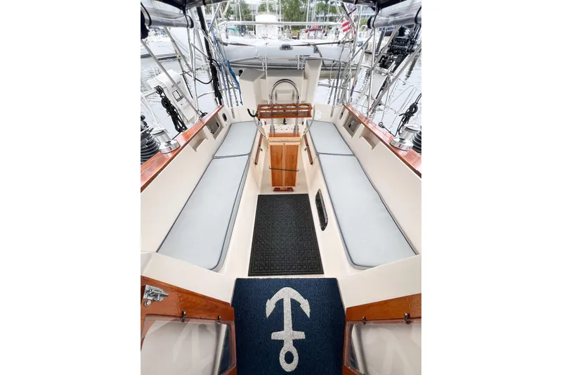 Delicia Yacht Photos Pics 1995 Island Packet 40 sailboat cockpit with cushioned seating and nautical-themed mat.