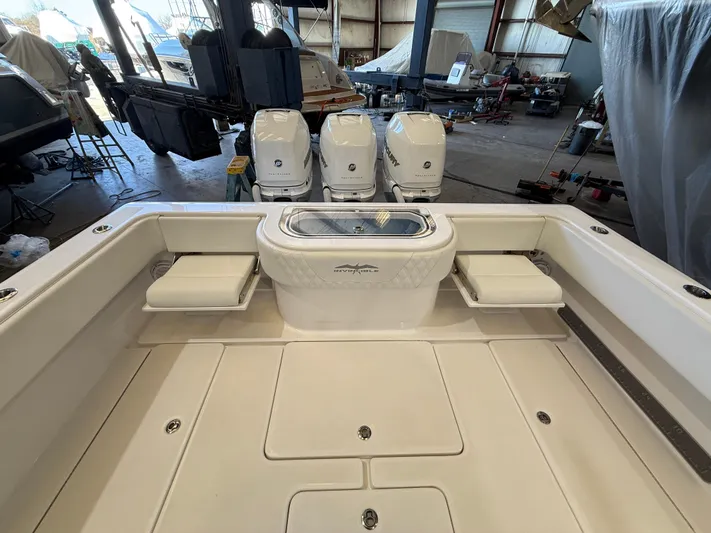  Yacht Photos Pics 2022 Invincible 39 Open Fisherman boat with triple engines in a storage facility.