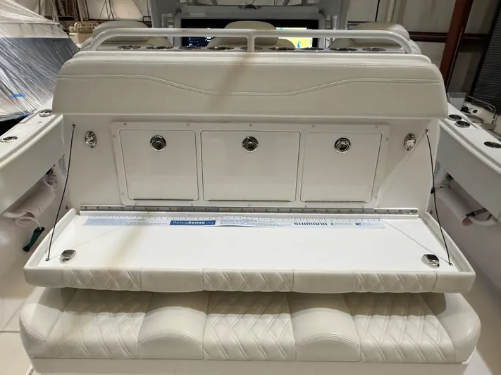  Yacht Photos Pics 2022 Invincible 39 Open Fisherman boat seating and storage area, featuring white cushioned seats.