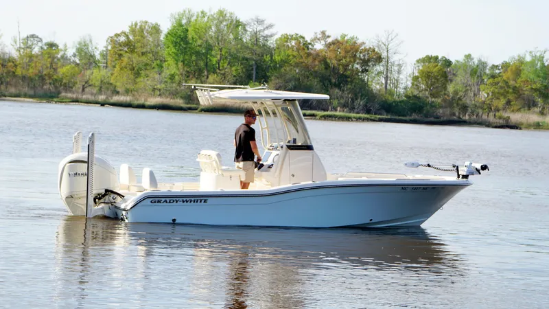  Yacht Photos Pics 2024 Grady-White 231 Coastal Explorer boat on calm water, with trees in the background.