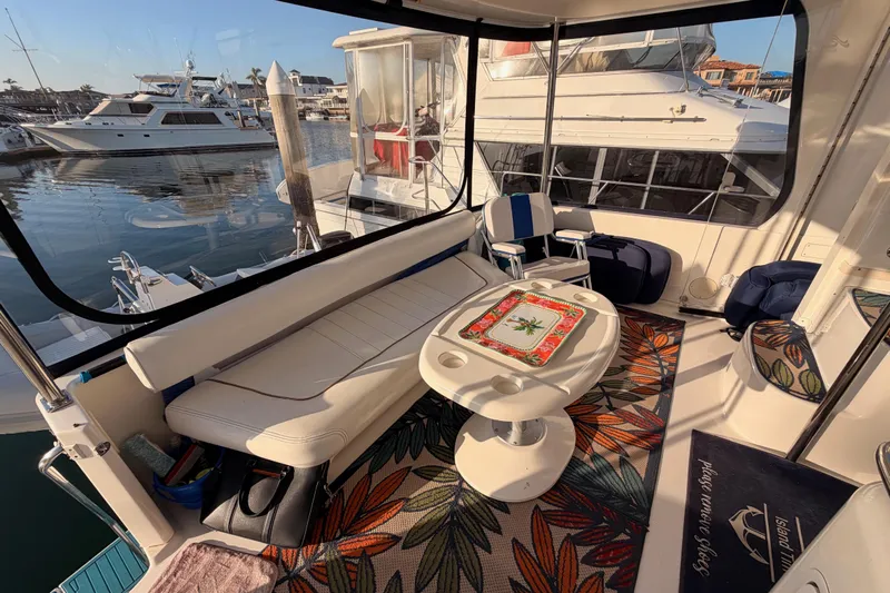 Island Time Yacht Photos Pics 1998 Sea Ray 420 Aft Cabin yacht interior with seating, table, and marina view.