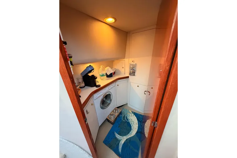Island Time Yacht Photos Pics Laundry area in 1998 Sea Ray 420 Aft Cabin with washer, counter, and fish-themed rug.