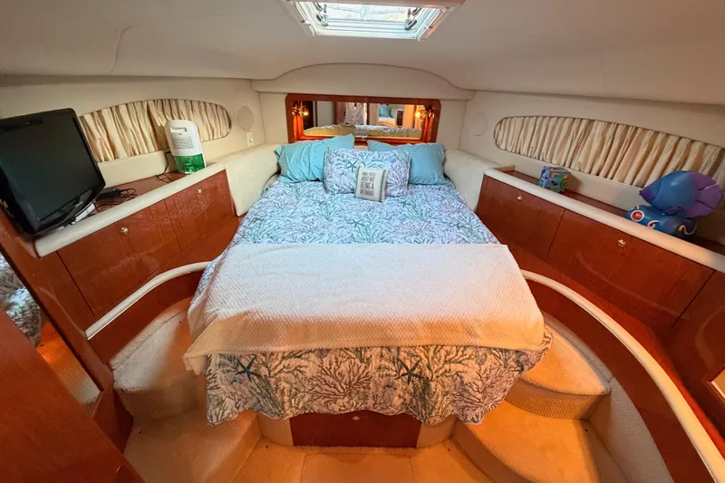 Island Time Yacht Photos Pics Luxurious 1998 Sea Ray 420 Aft Cabin bedroom with cozy bedding and elegant wood cabinetry.