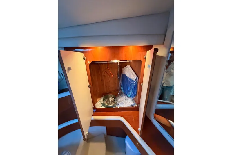 Island Time Yacht Photos Pics 1998 Sea Ray 420 Aft Cabin interior with open wooden cabinet and storage items.