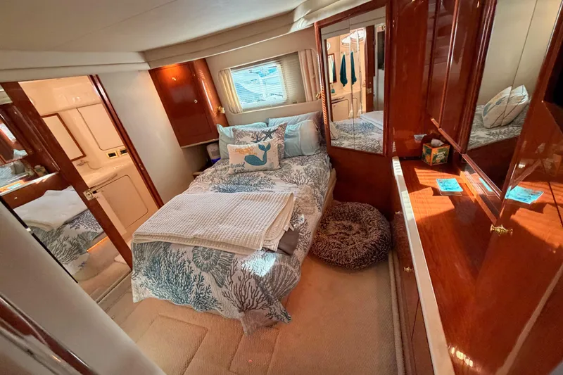 Island Time Yacht Photos Pics Luxurious 1998 Sea Ray 420 Aft Cabin bedroom with elegant wood finishes and cozy bedding.