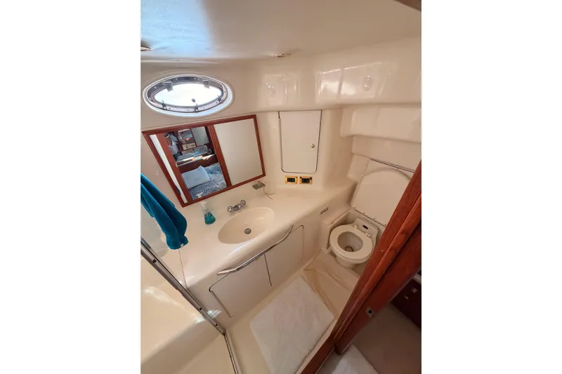 Island Time Yacht Photos Pics Bathroom interior of 1998 Sea Ray 420 Aft Cabin yacht, featuring sink and toilet.