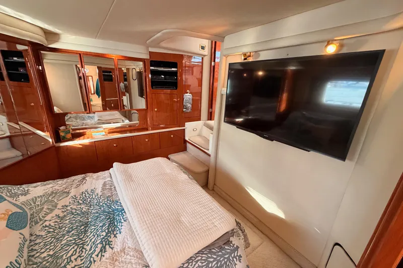 Island Time Yacht Photos Pics Luxurious 1998 Sea Ray 420 Aft Cabin interior with TV and elegant wood cabinetry.