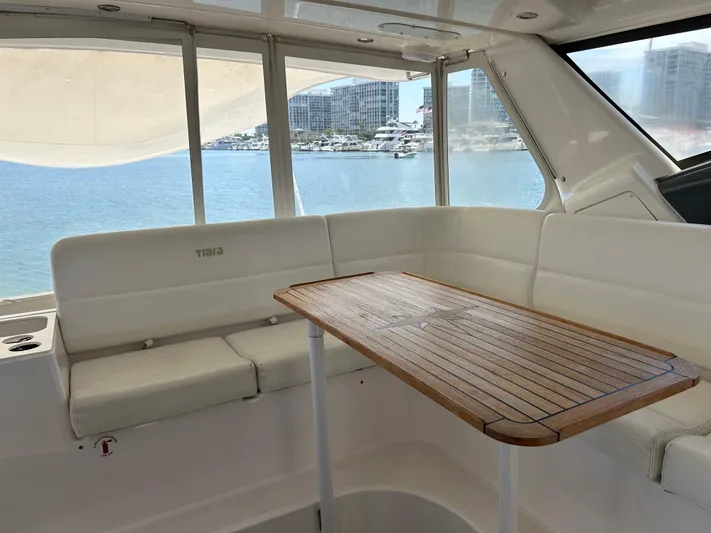 Dividend Yacht Photos Pics Interior of 2000 Tiara Yachts 5000 Express with wooden table and white seating.