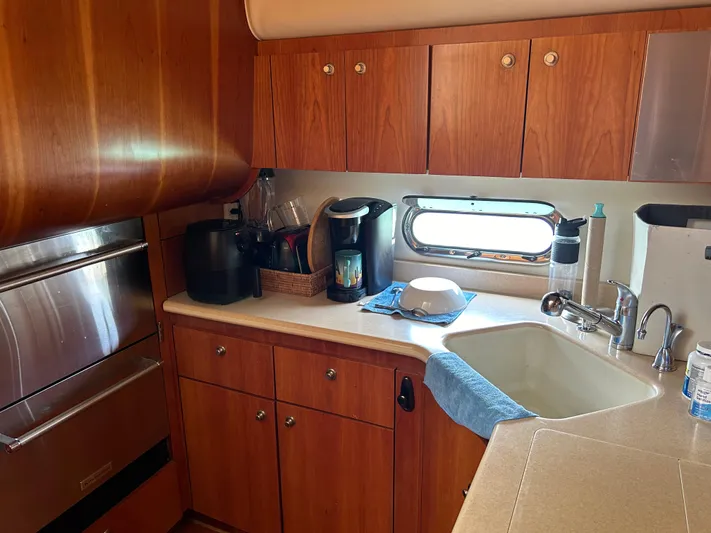 Dividend Yacht Photos Pics 2000 Tiara Yachts 5000 Express kitchen with wood cabinets and modern appliances.