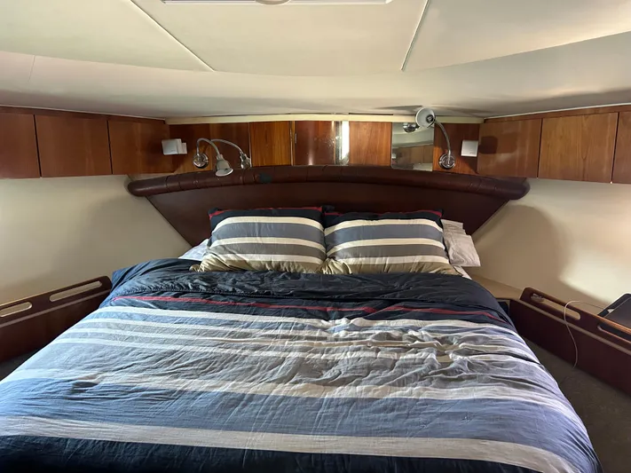 Dividend Yacht Photos Pics Luxurious bedroom interior of 2000 Tiara Yachts 5000 Express with striped bedding.