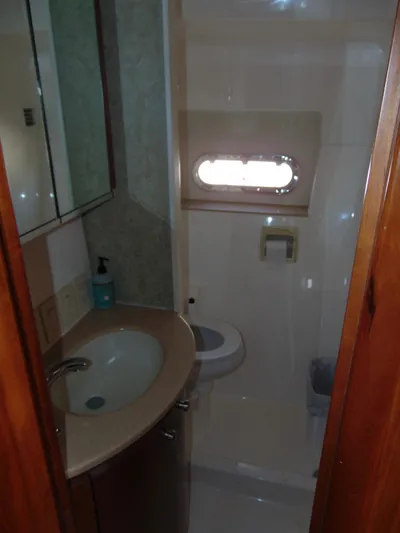 Dividend Yacht Photos Pics Bathroom interior of 2000 Tiara Yachts 5000 Express, featuring sink and porthole window.