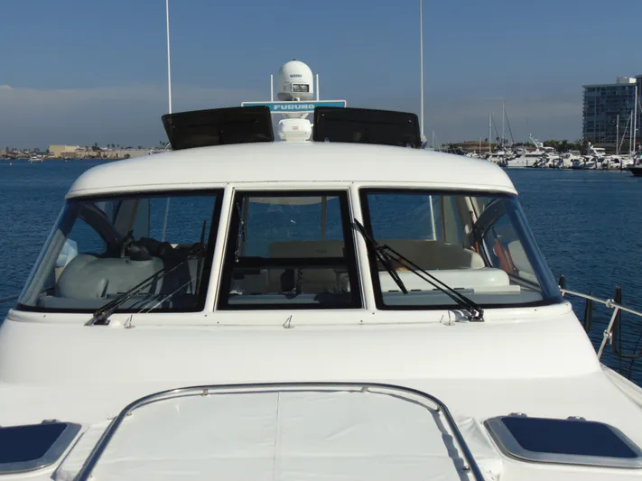 Dividend Yacht Photos Pics 2000 Tiara Yachts 5000 Express on water, front view with marina background.