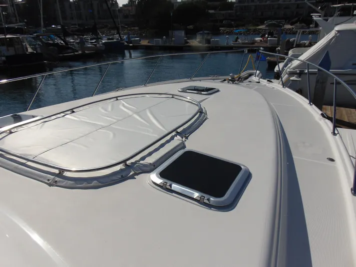 Dividend Yacht Photos Pics 2000 Tiara Yachts 5000 Express yacht deck with hatches, docked in marina.